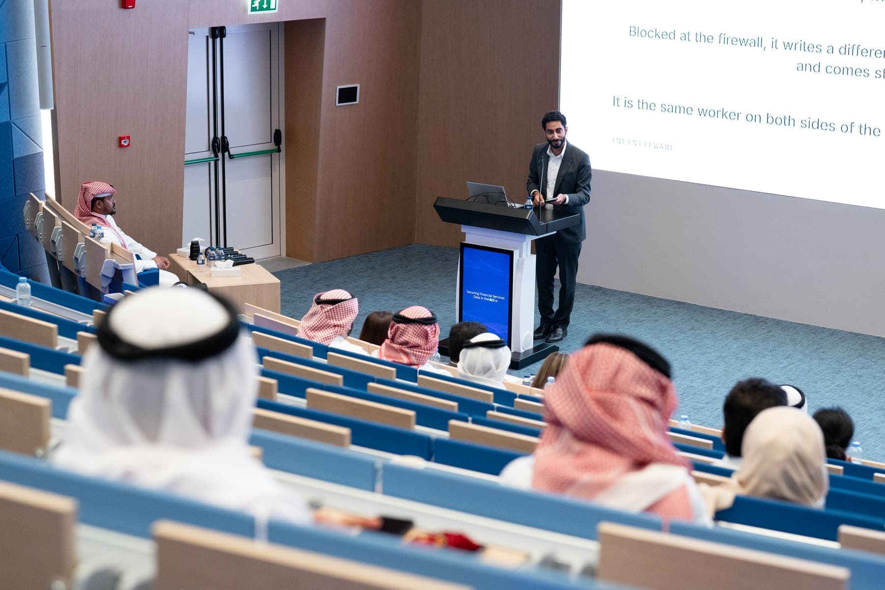 A full auditorium of customer service and data-handling staff from across Bahrain's financial services sector.
